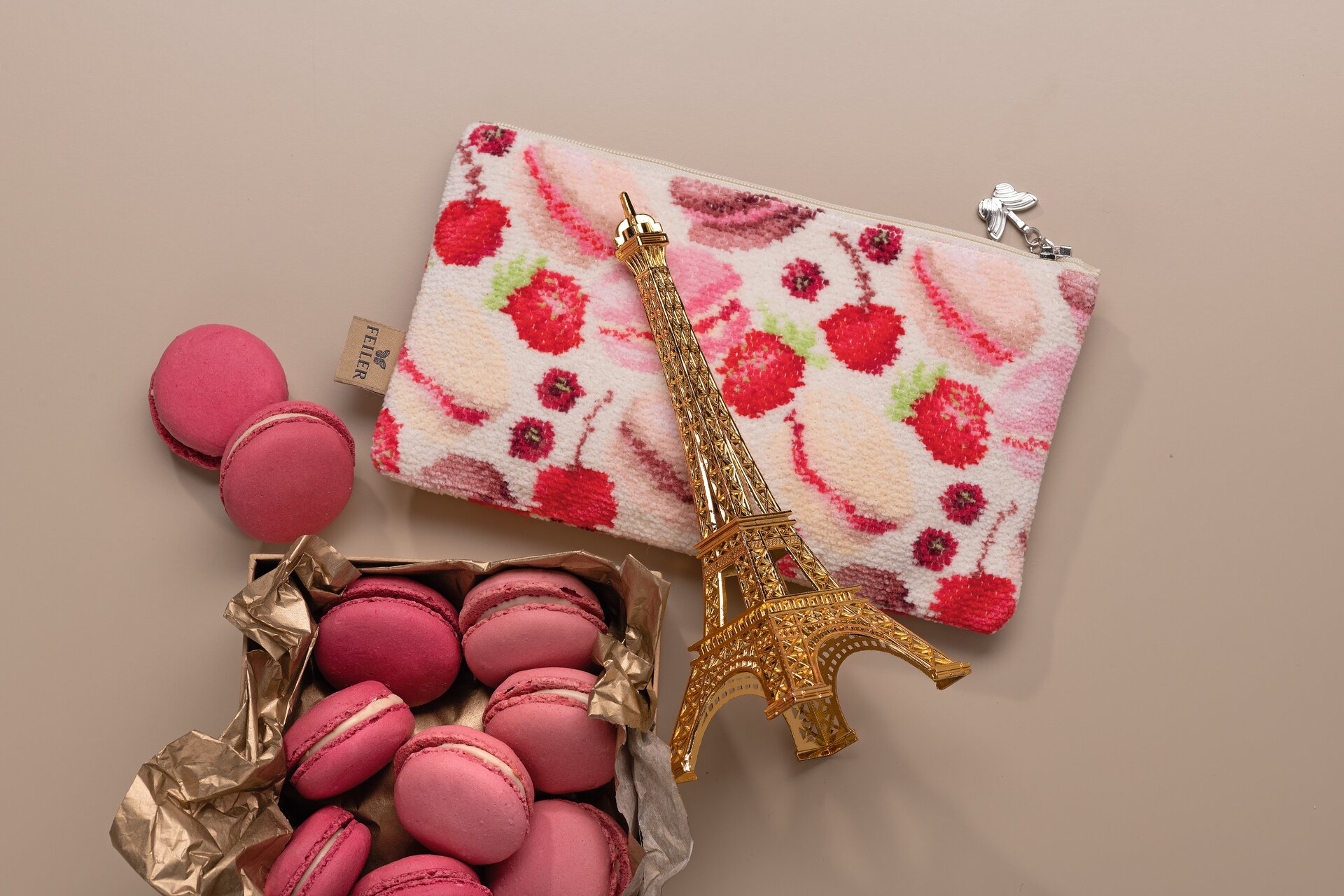 Rosa Macarons auf gemustertem Stoff – Luxuriöses FEILER Handtuch als Lifestyleaufnahme aus Original FEILER-Chenille, Made in Germany.