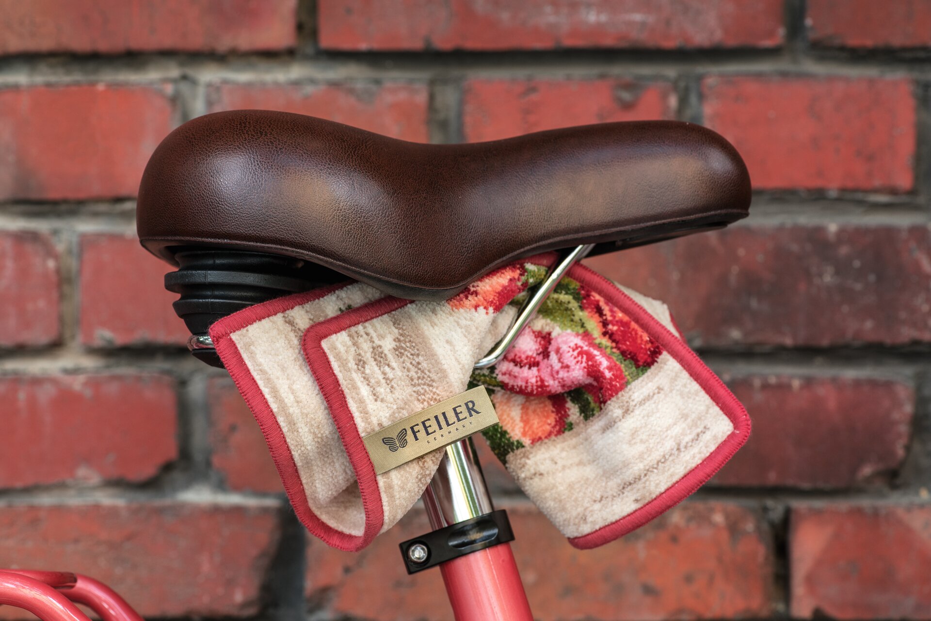 Feiler Chenille-Tuch auf Fahrradsattel – Luxuriöses FEILER Handtuch der Kollektion AMSTERDAM als Lifestyleaufnahme aus Original FEILER-Chenille, Made in Germany.