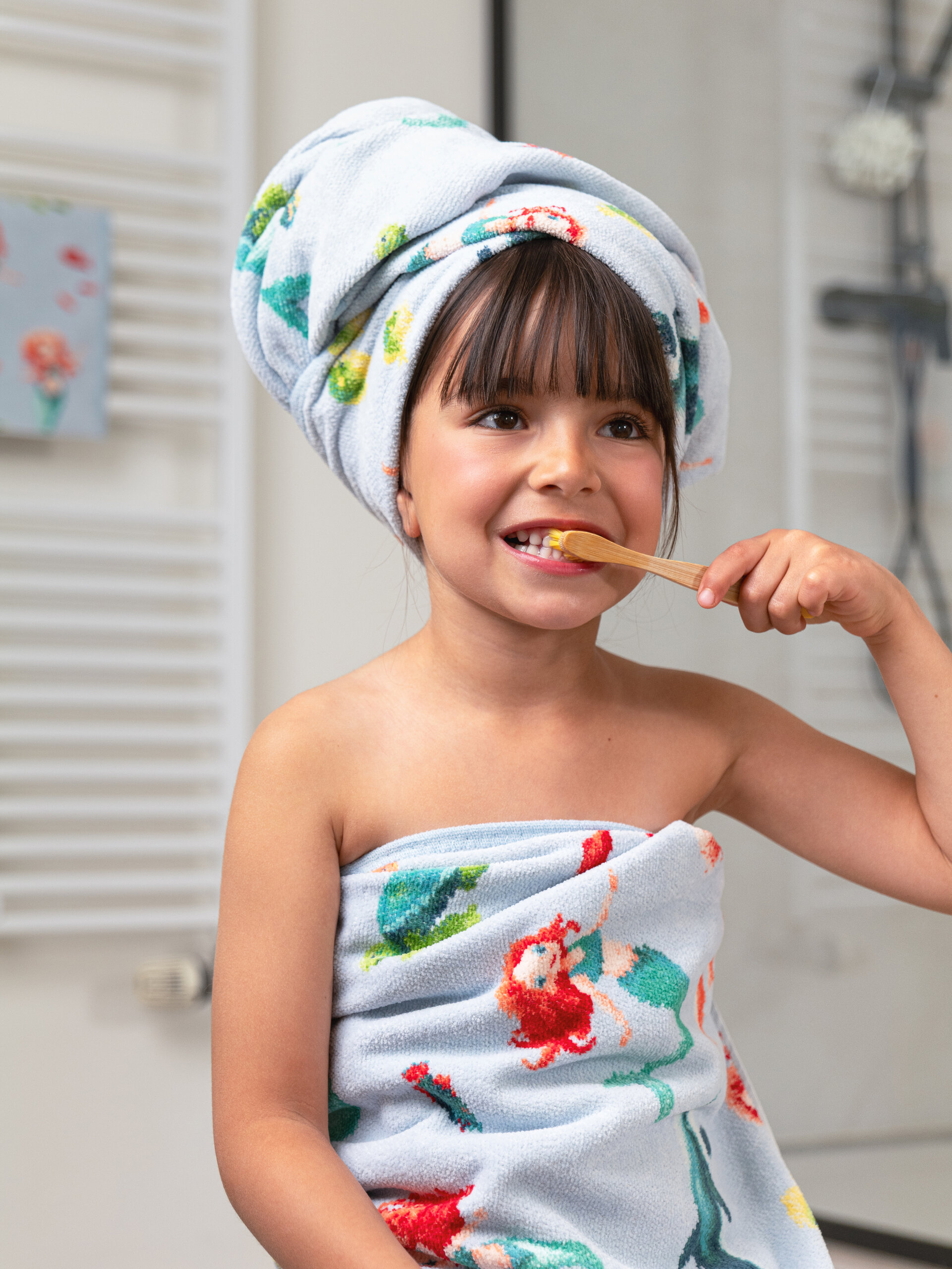 Kind mit geblümtem Handtuch im Bad – Luxuriöses FEILER Handtuch der Kollektion MERMAID DREAMS als Lifestyleaufnahme aus Original FEILER-Chenille, Made in Germany.