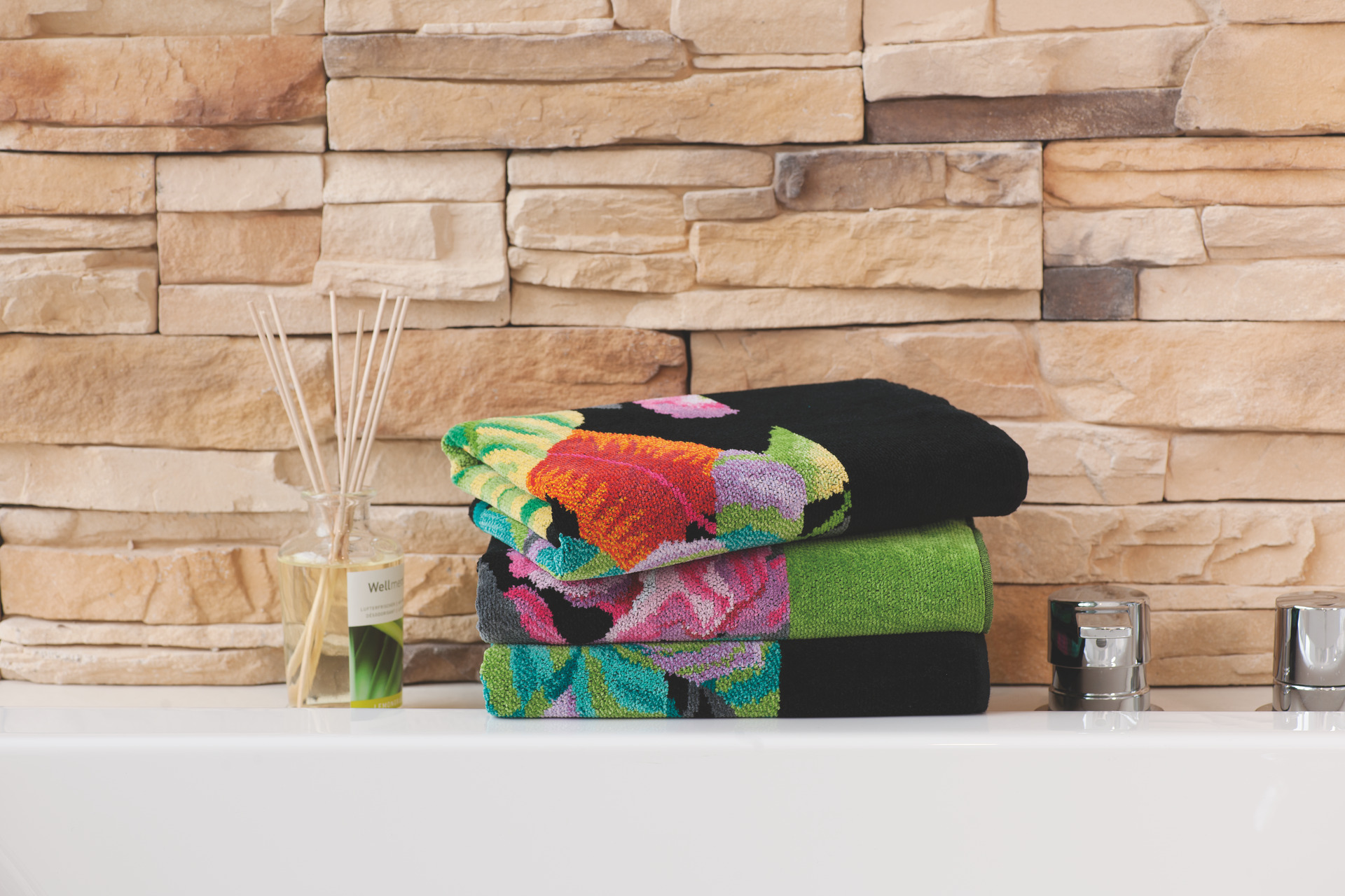 Bunte Premium Badtextilien gestapelt – Luxuriöses FEILER Handtuch der Kollektion RAINFOREST als Lifestyleaufnahme aus Original FEILER-Chenille, Made in Germany.