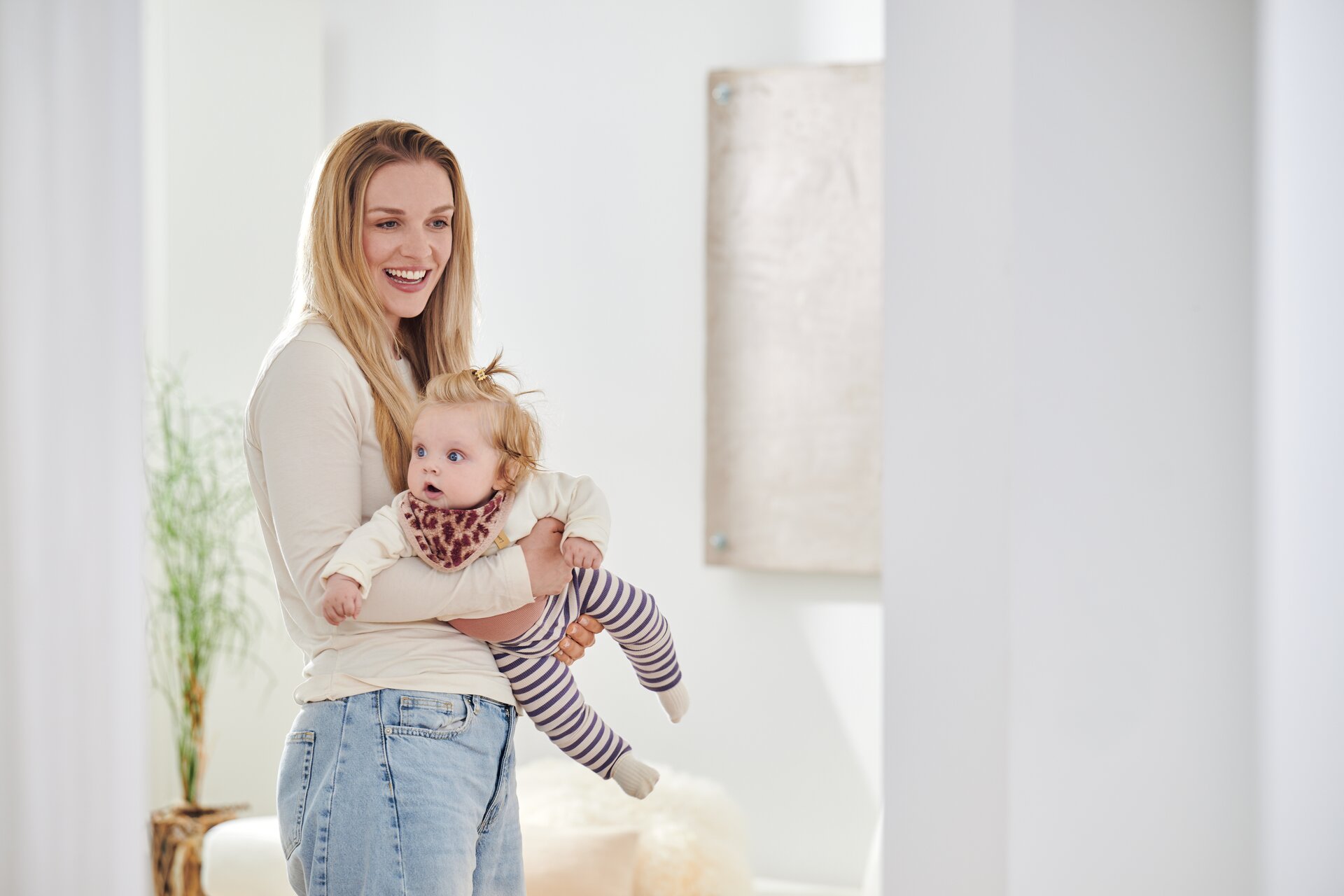 Second lifestyle image of a model with a baby wearing the FEILER WILD LEO triangle scarf, size 41 × 14 cm, made from Original FEILER chenille.