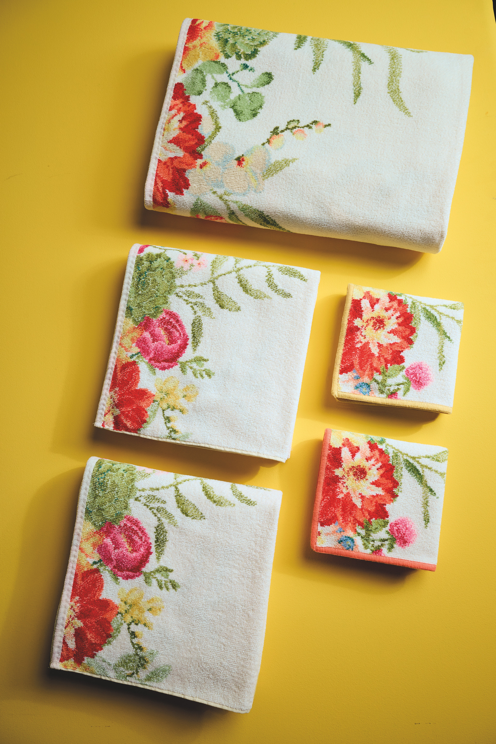 Florale Handtücher auf gelbem Hintergrund – Luxuriöses FEILER Handtuch der Kollektion SUMMER DAY als Lifestyleaufnahme aus Original FEILER-Chenille, Made in Germany.