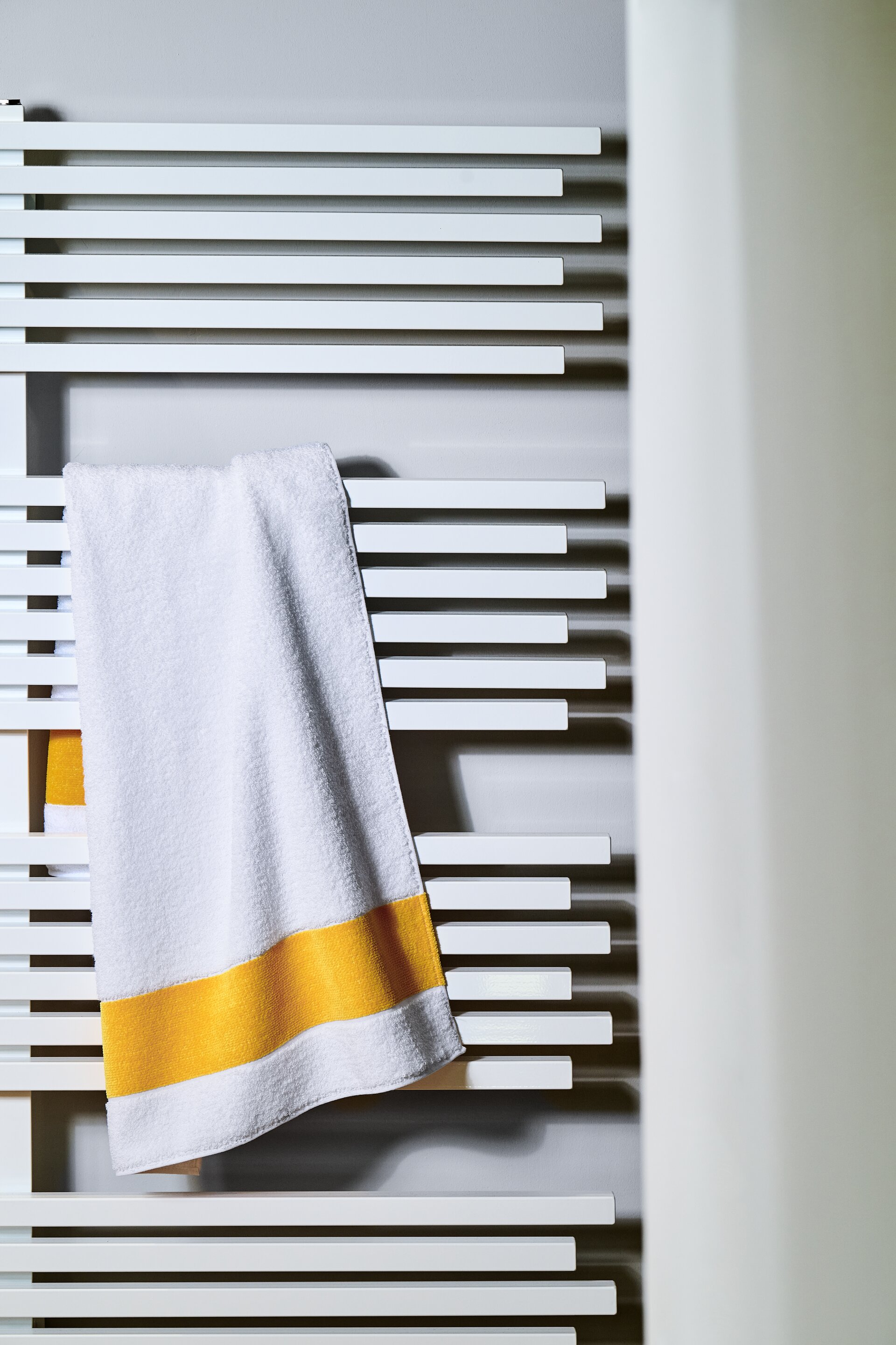 Hochwertiges Handtuch mit gelbem Akzent – Luxuriöses FEILER Handtuch der Kollektion EXCLUSIV als Lifestyleaufnahme aus Original FEILER-Chenille, Made in Germany.
