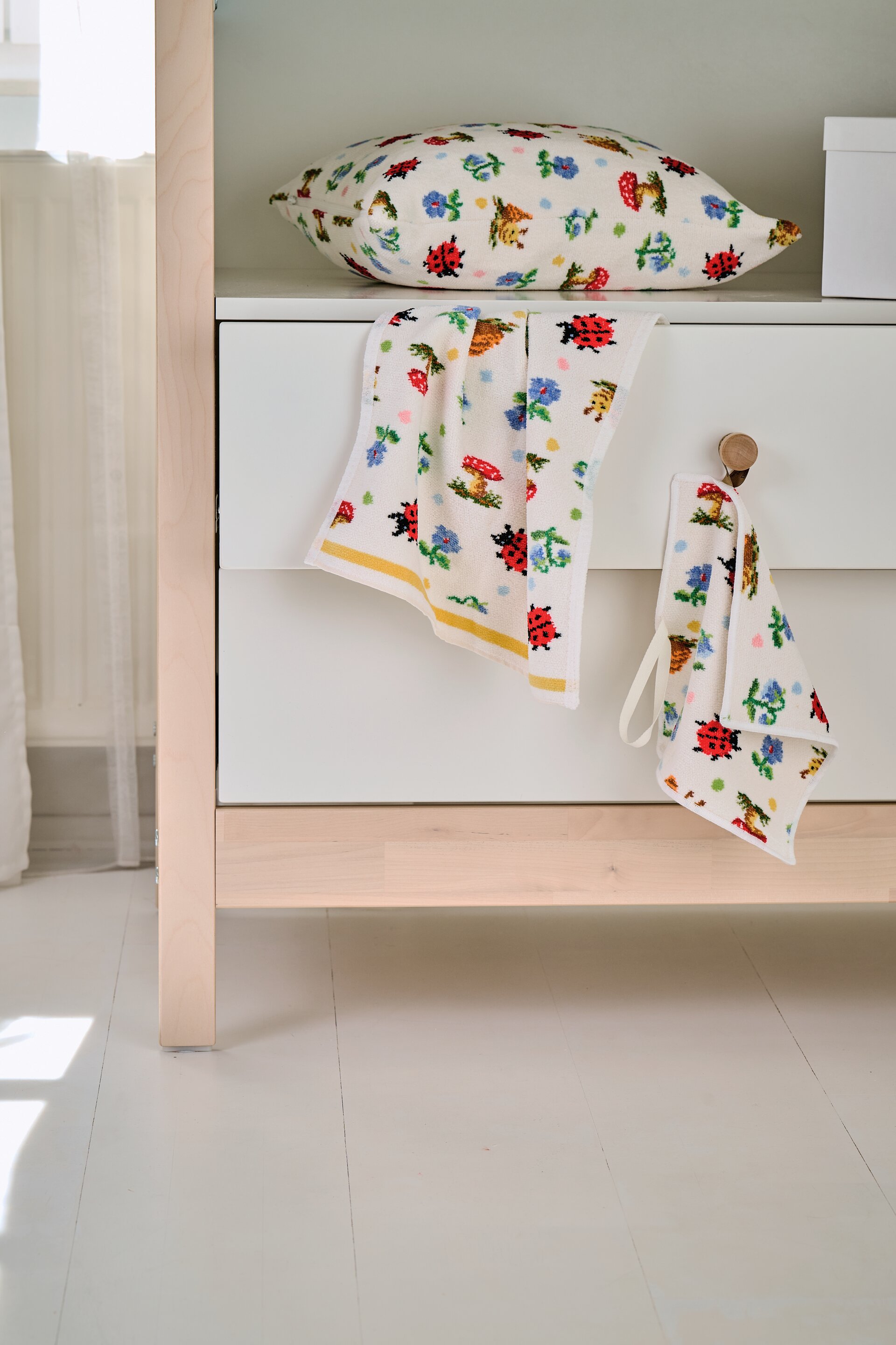 Gemustertes Handtuch und Kissen im Badezimmer – Luxuriöses FEILER Kissen der Kollektion PAULI DOTS als Lifestyleaufnahme aus Original FEILER-Chenille, Made in Germany.