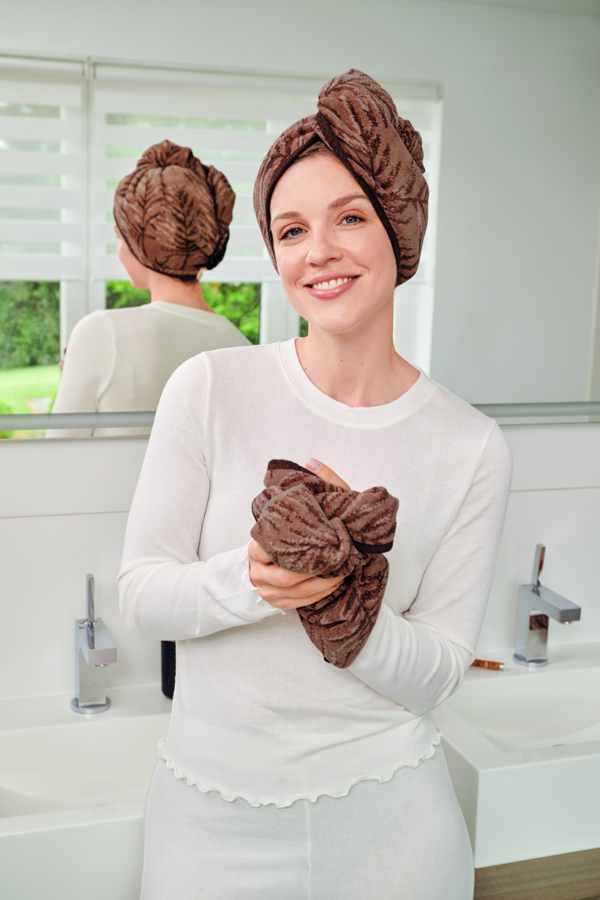 Second lifestyle view of the FEILER OASIS NIGHTS hand towel turban worn by a model, showing the soft Original FEILER chenille texture.
