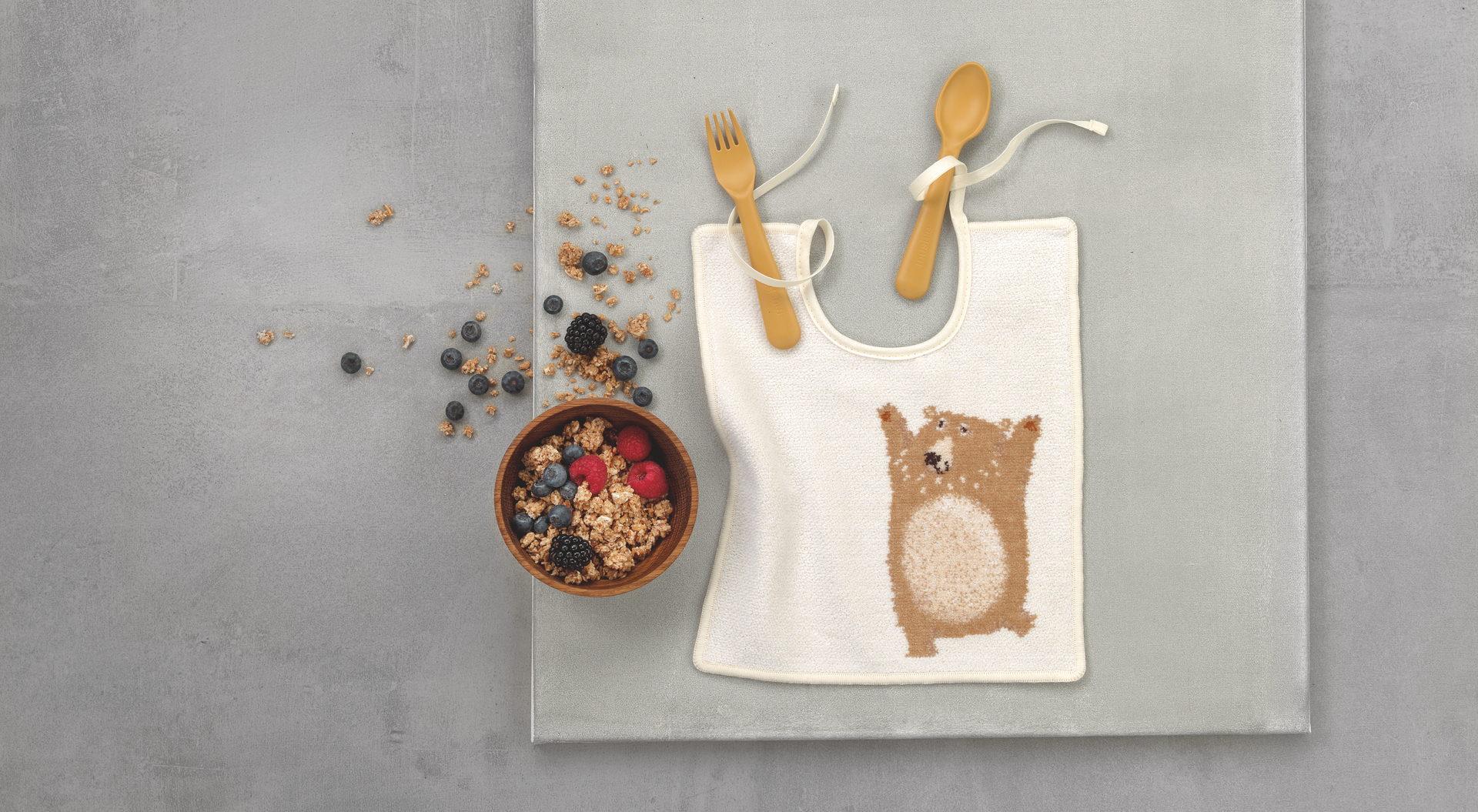 Baby-Lätzchen mit Bärenmotiv und Besteck – Luxuriöses FEILER Lätzchen der Kollektion BEN BAER als Lifestyleaufnahme aus Original FEILER-Chenille, Made in Germany.