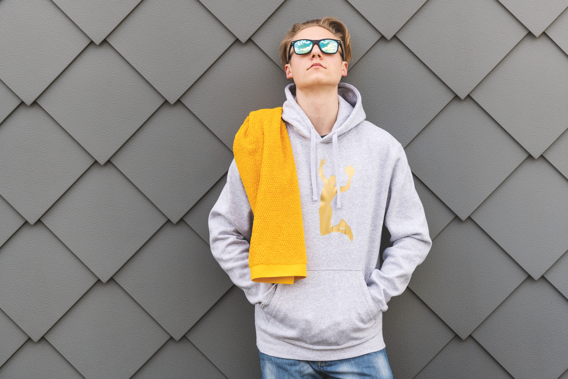 Person mit gelbem Handtuch und Hoodie – Luxuriöses FEILER Handtuch der Kollektion IBIZA als Lifestyleaufnahme aus Original FEILER-Chenille, Made in Germany.