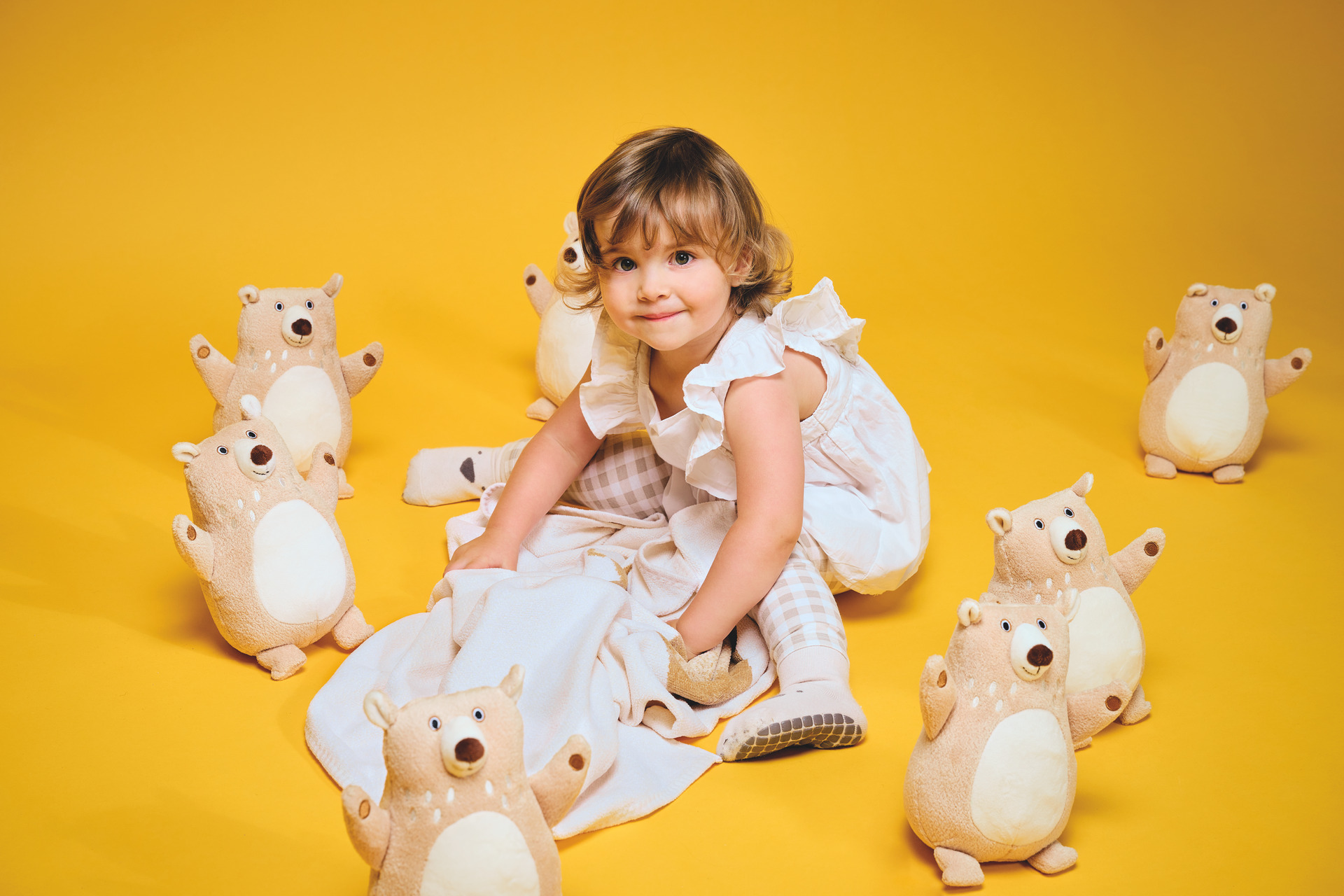 Kind mit Kuscheltieren auf gelbem Hintergrund – Luxuriöses FEILER Handtuch der Kollektion BEN BAER als Lifestyleaufnahme aus Original FEILER-Chenille, Made in Germany.