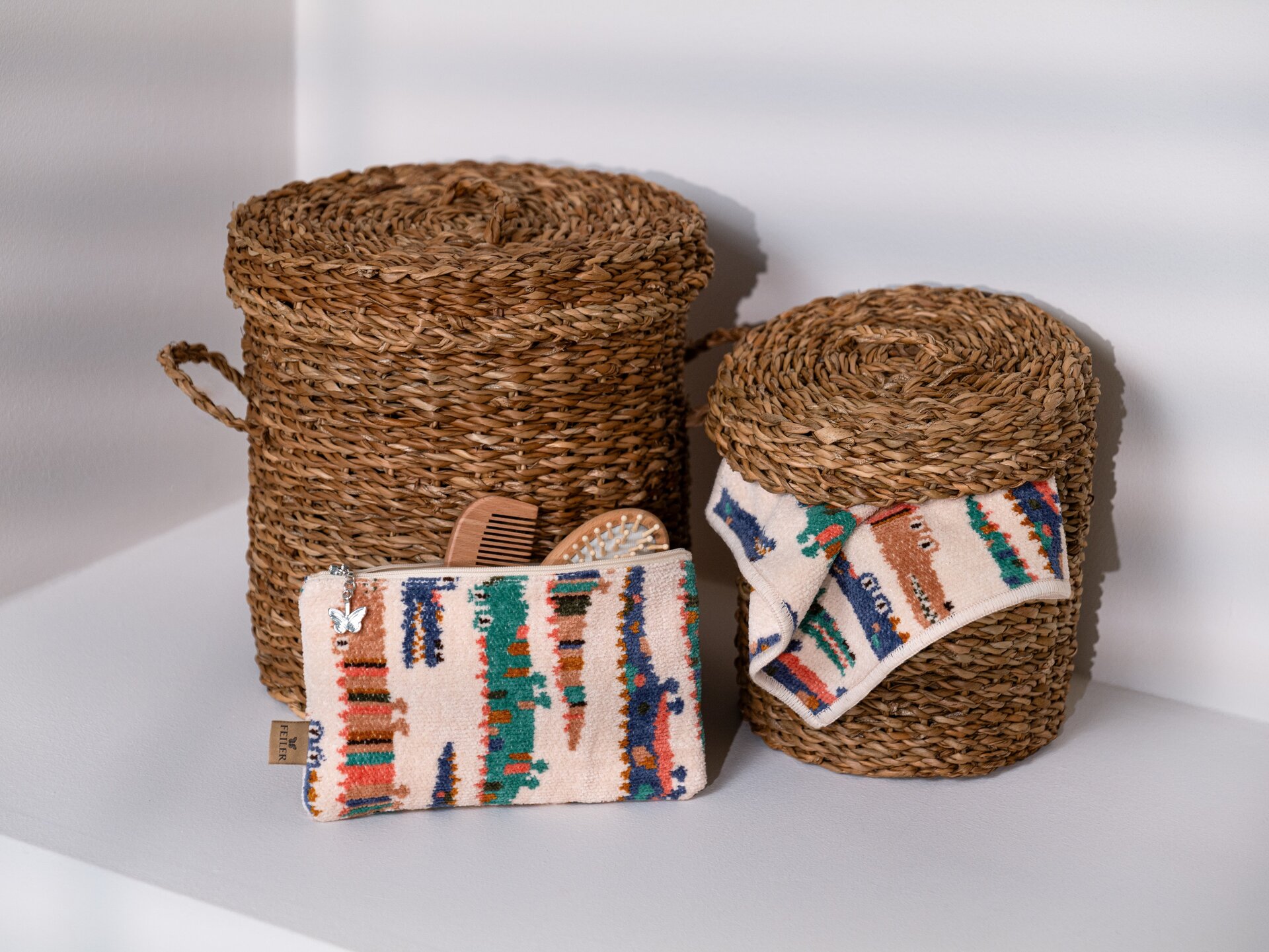 Set-Ansicht der FEILER KROKO Kollektion mit verschiedenen Babytextilien und Accessoires aus Original FEILER-Chenille in Körben.