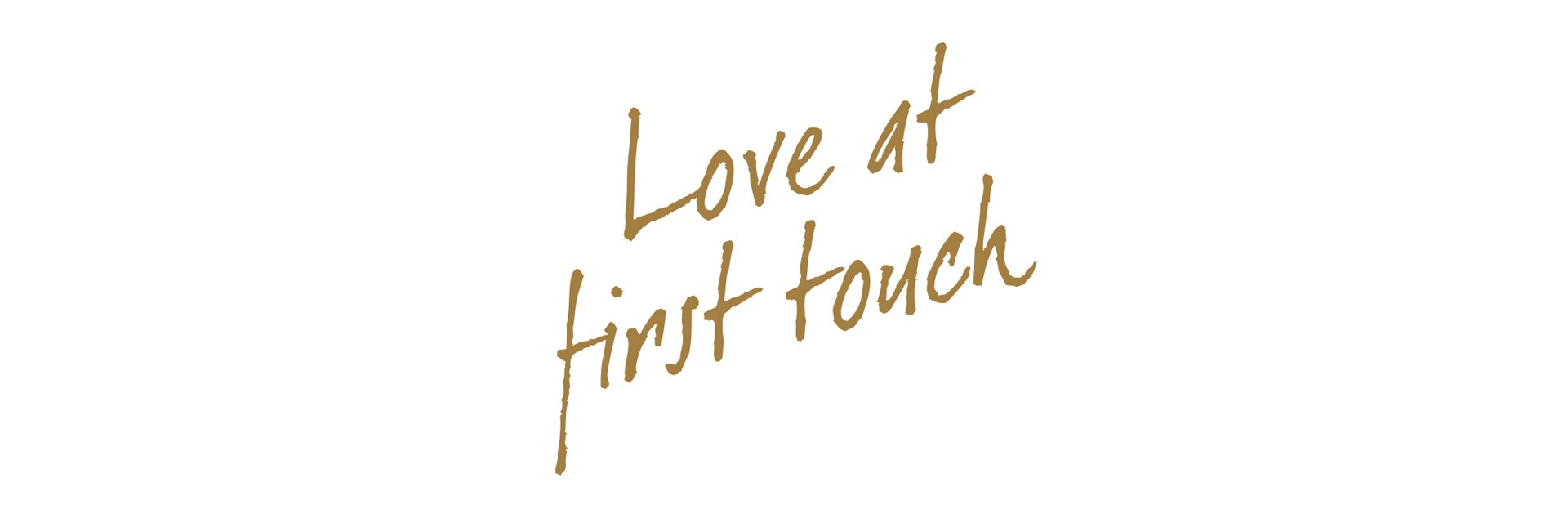 Elegante goldene Schrift auf weißem Hintergrund: ‚Love at first touch‘.