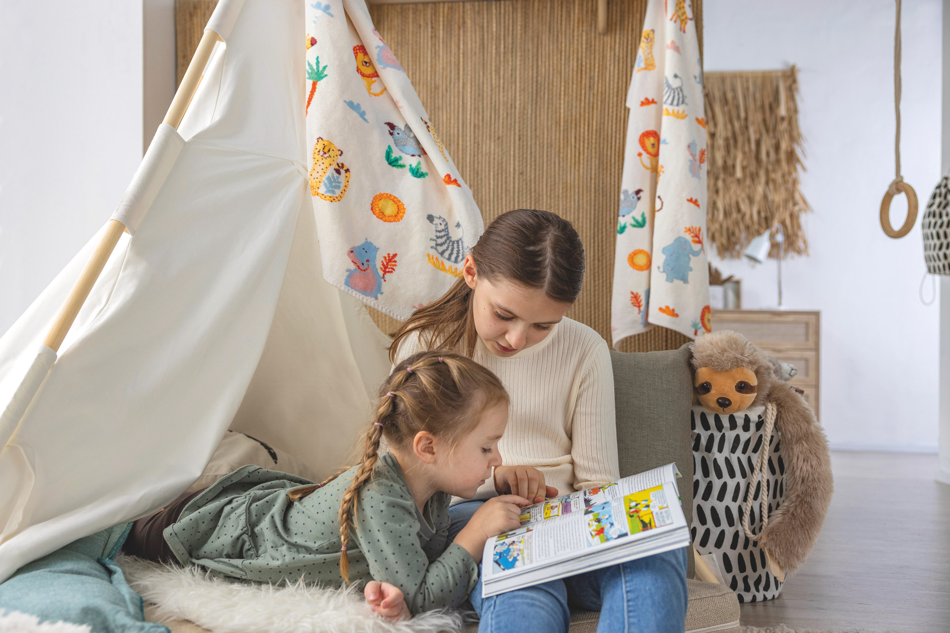 Kinder im Spielzelt mit Buch – Luxuriöses FEILER Handtuch der Kollektion WILD SAFARI als Lifestyleaufnahme aus Original FEILER-Chenille, Made in Germany.