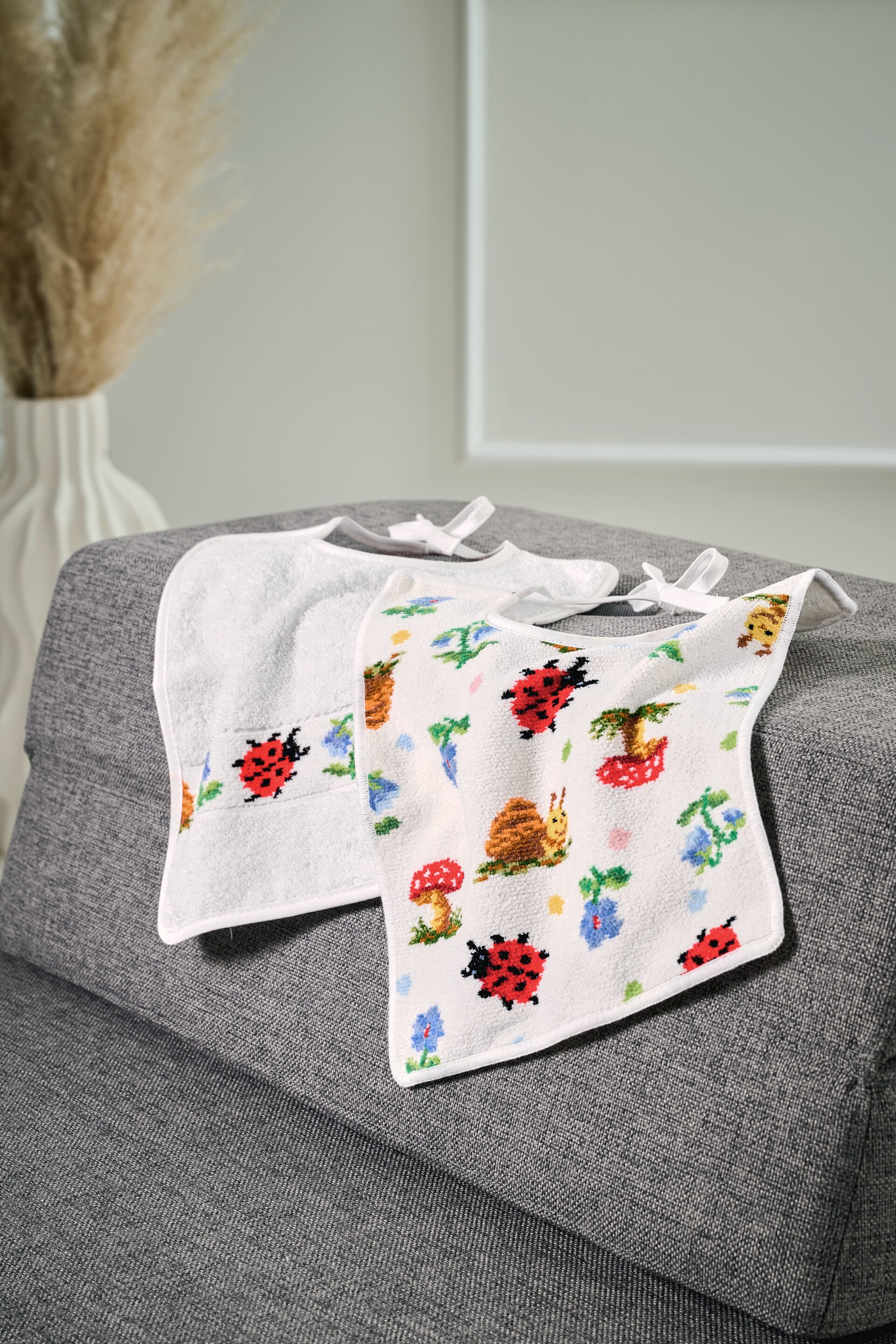 Frottier-Baby-Lätzchen mit Tiermotiven – Luxuriöses FEILER Lätzchen der Kollektion PAULI DOTS PAULI als Lifestyleaufnahme aus Frottier mit Original FEILER-Chenille-Bordüre, Made in Germany.