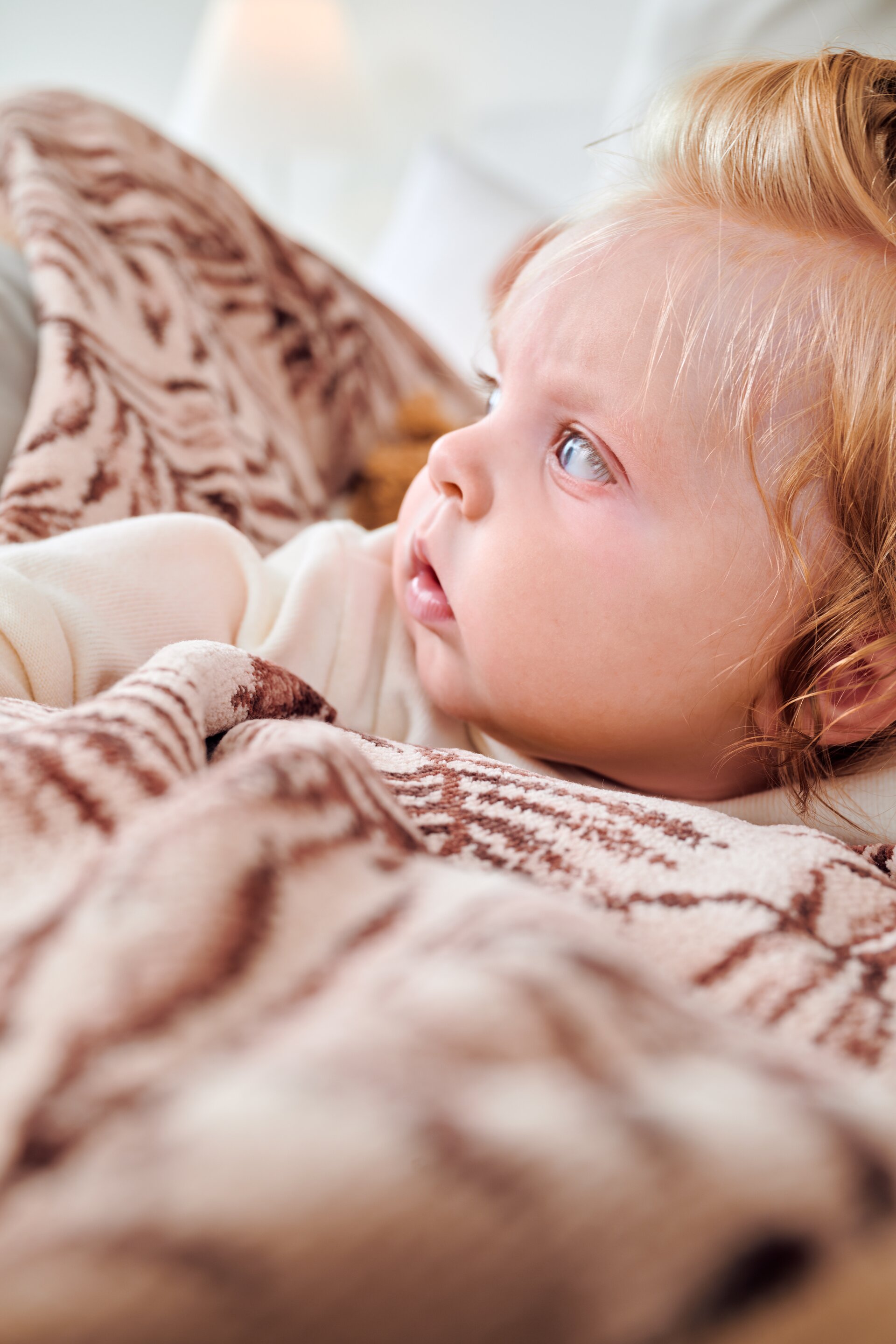Lifestyle image of the FEILER DESERT PALMS baby collection with a baby, featuring soft textiles made from Original FEILER chenille in Germany.