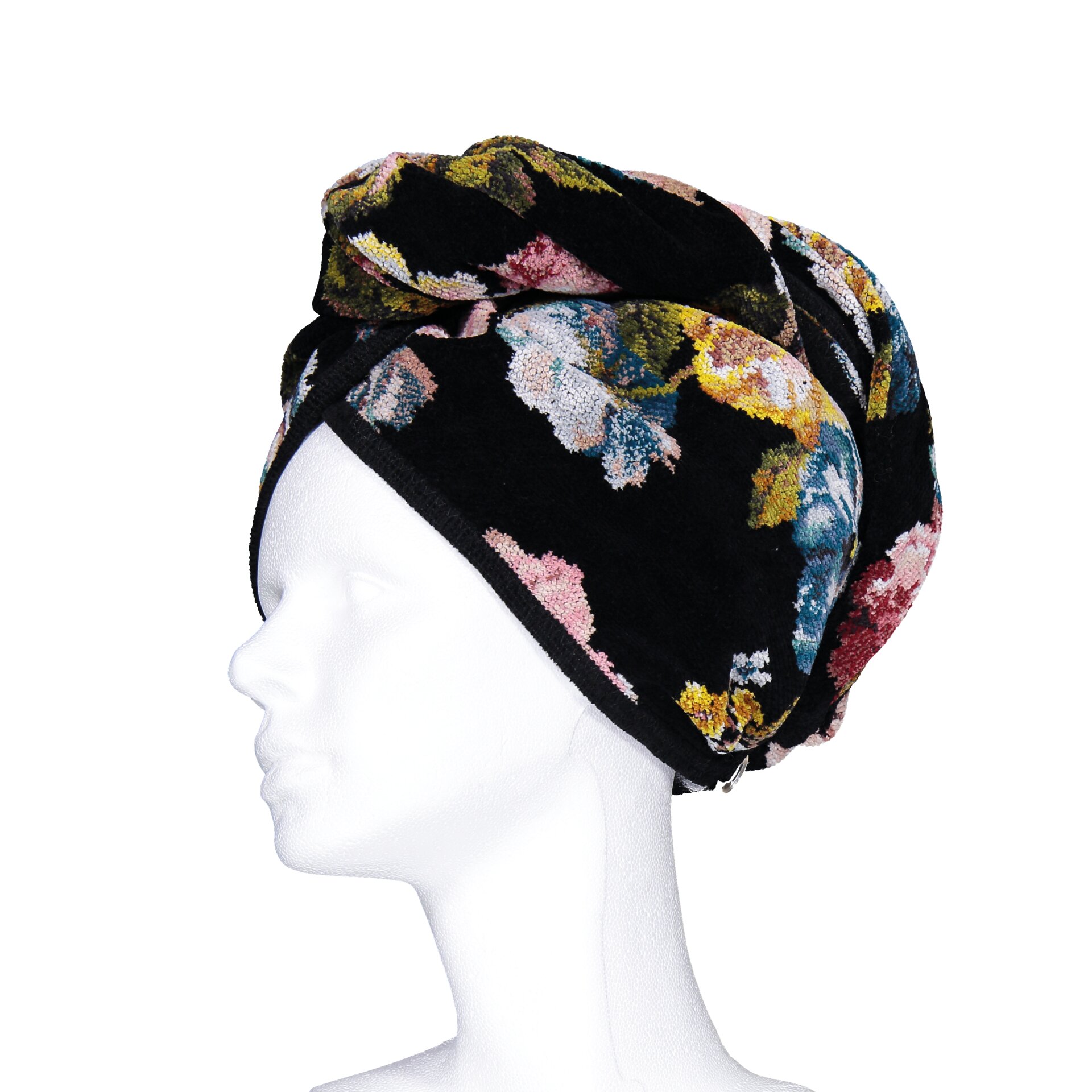 Adult mannequin with floral-patterned, dark fabric head wrap, flowers in pink, blue, and yellow hues.