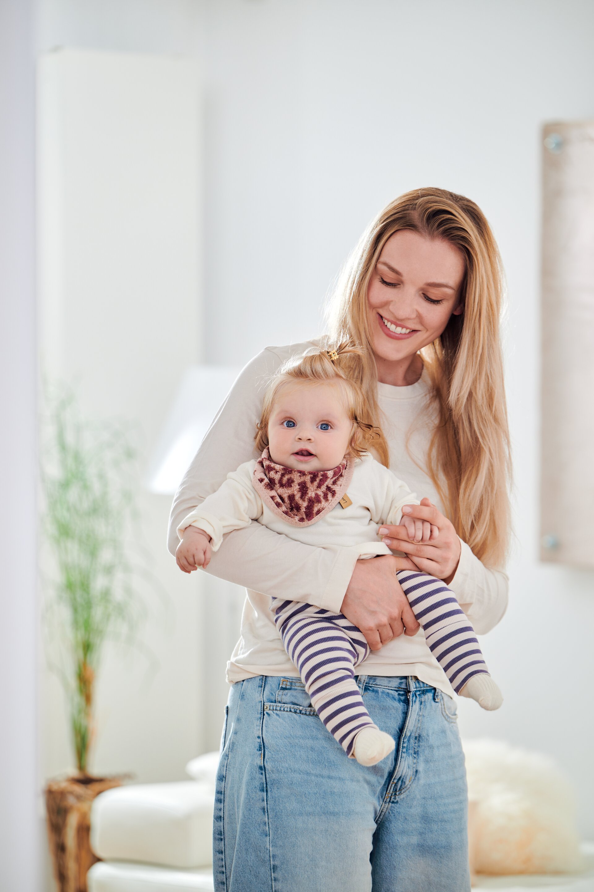 Erste Lifestyle-Aufnahme eines Models mit Baby und FEILER WILD LEO Dreieckstuch, Größe 41 × 14 cm, aus Original FEILER-Chenille.