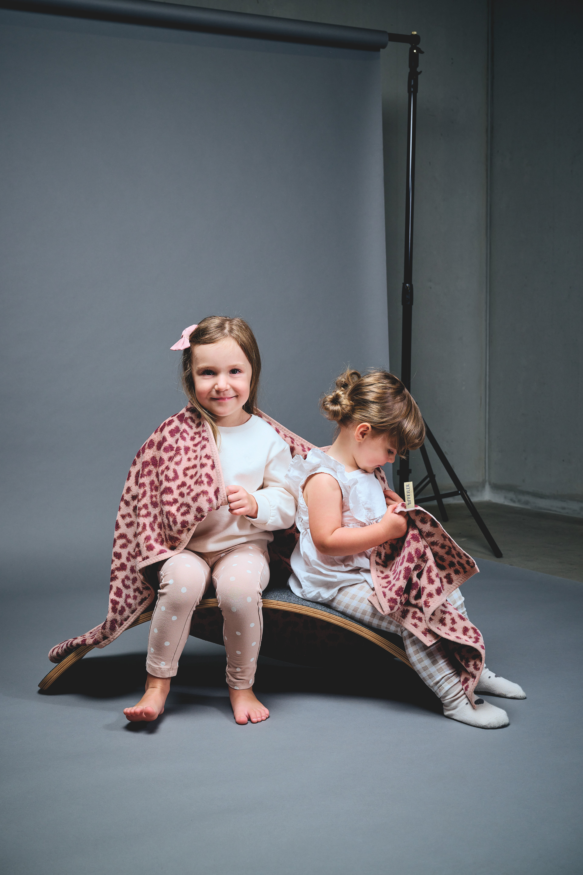 Kinder mit weicher Decke – Luxuriöse FEILER Decke der Kollektion WILD LEO als Lifestyleaufnahme aus Original FEILER-Chenille, Made in Germany.