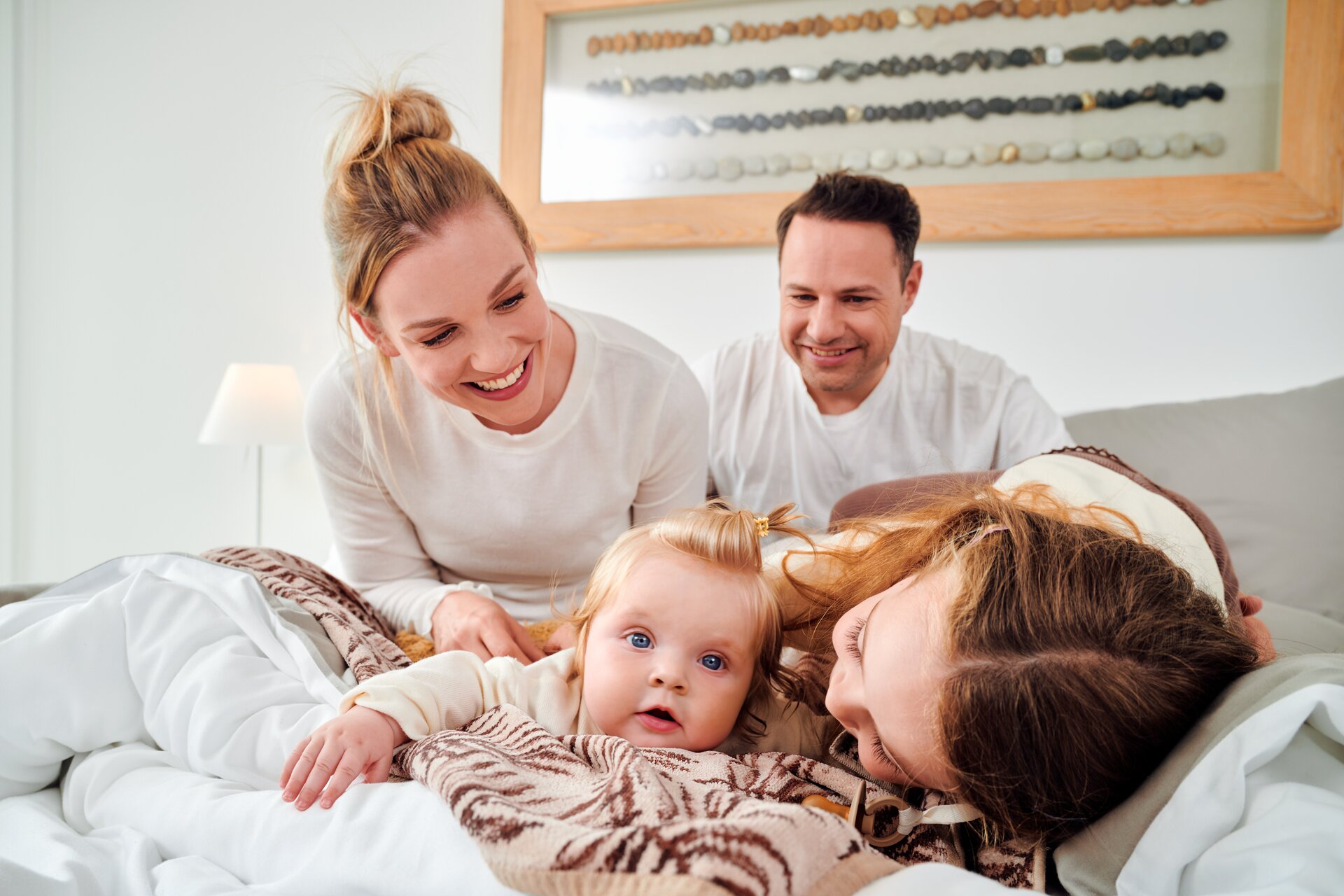 Set-Ansicht verschiedener FEILER DESERT PALMS Babytextilien und Handtücher aus Original FEILER-Chenille mit Models auf einem Sofa