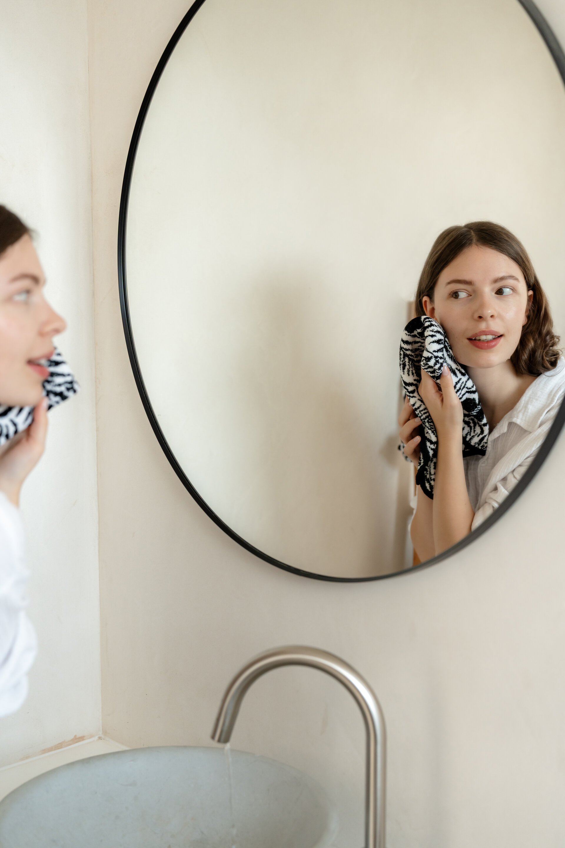 Frau im Badezimmer mit Chenille-Tuch – Luxuriöses FEILER Handtuch der Kollektion JUNGLE als Lifestyleaufnahme aus Original FEILER-Chenille, Made in Germany.