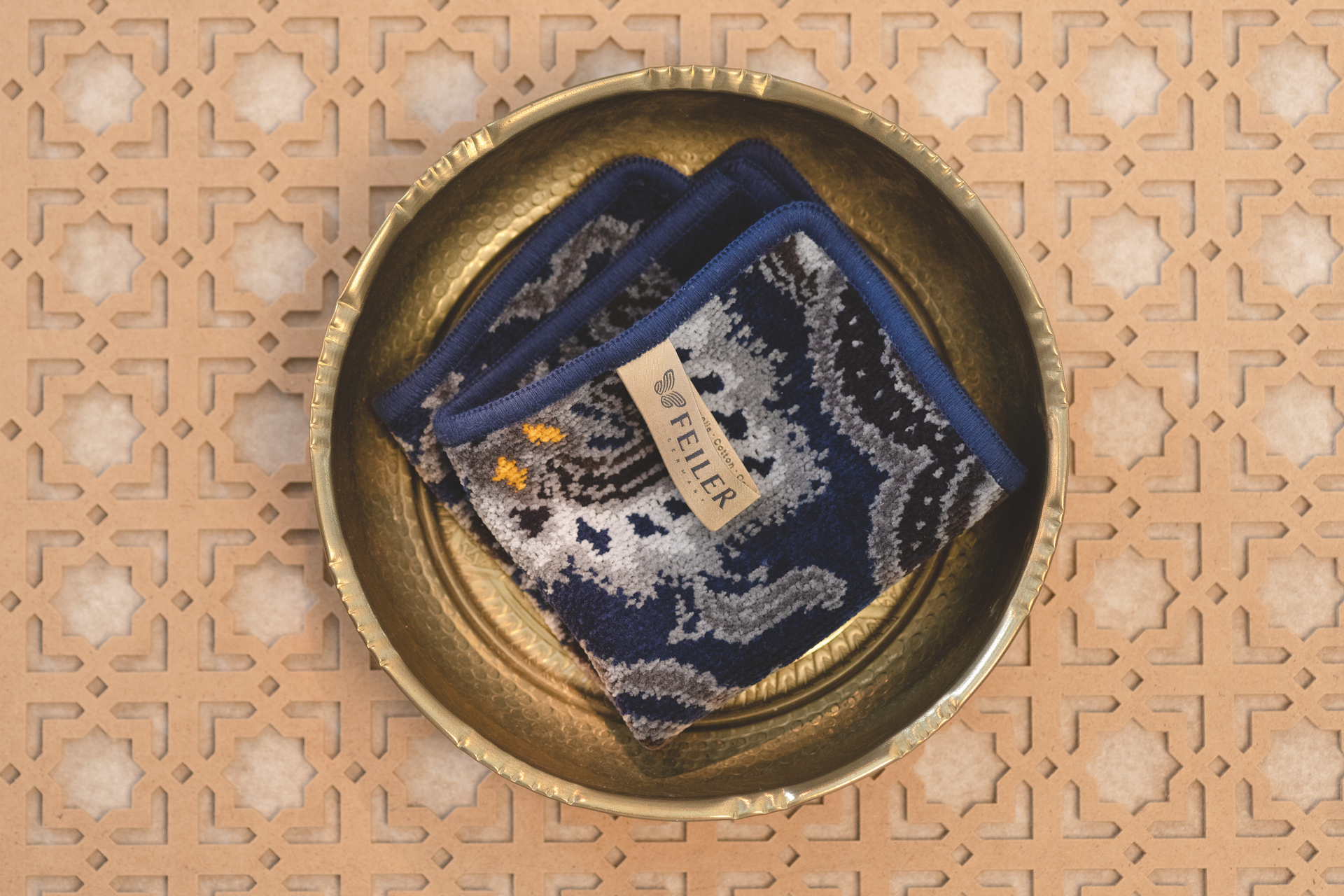 Feiler Chenille-Tuch in Blau-Gold-Muster – Luxuriöses FEILER Handtuch der Kollektion DJAMAL als Lifestyleaufnahme aus Original FEILER-Chenille, Made in Germany.